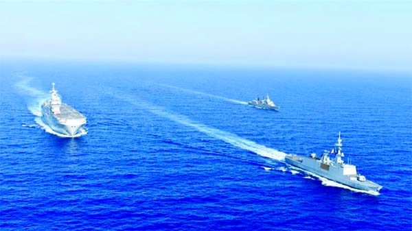 Greek and French vessels sail in formation during a joint military exercise in the Mediterranean Sea.
