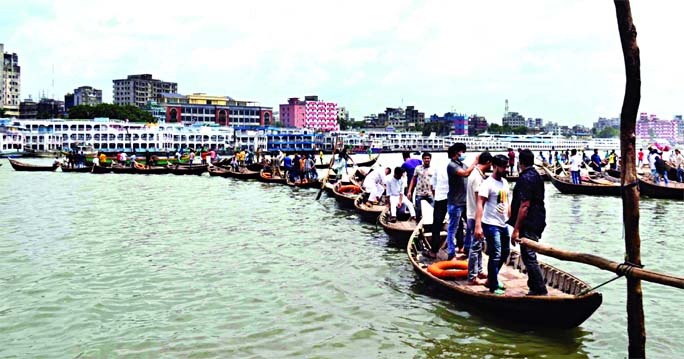 People form a human chain with boats in Buriganga River on Saturday protesting the BIWTA's initiative to suspend the operation of boats in the river.
