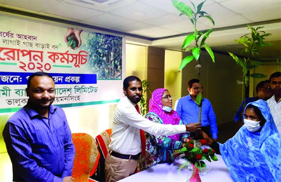 Kamal Hossain, Manager of Islami Bank's Bhaluka Branch, distributes saplings among the clients at the branch premises on Sunday, marking the 100th birth anniversary of the Father of the Nation, Sheikh Mujibur Rahman. Among others Nargis Akhtar, Upazila A