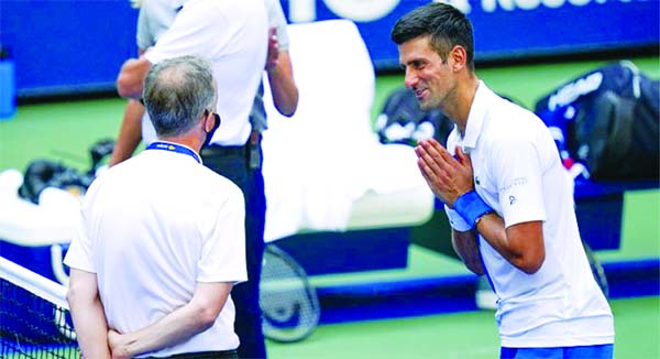 Novak Djokovic (right) of Serbia, talks with the umpire after inadvertently hitting a line judge with a ball after hitting it in reaction to losing a point against Pablo Carreno Busta at USTA Billie Jean King National Tennis Center in New York on Sunday.