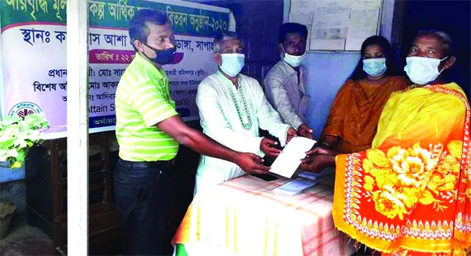 Caritas officials hand over grant support to a marginal farmer at Sapahar in Mohadevpur of Naogaon district on Monday under the initiative of Asha project.