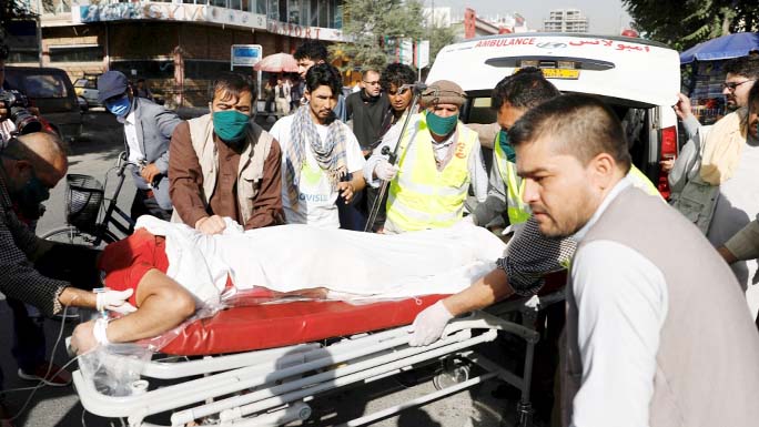 Afghan men carry an injured to a hospital after a blast in Kabul on Wednesday.