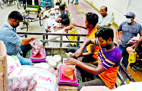 People are seen in a queue at Motijheel in the capital on Sunday to buy onion from TCB's truck at Tk 30 per kg.