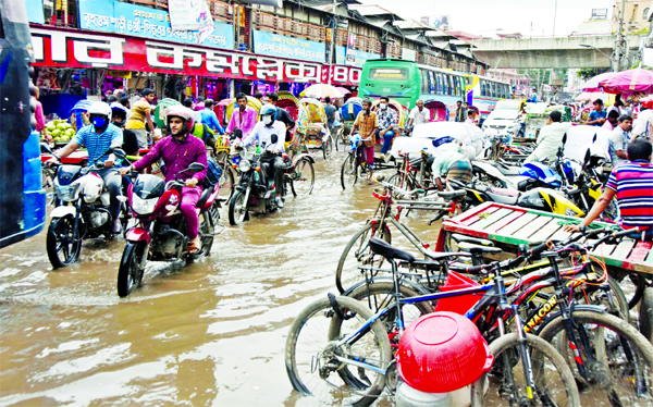 The road in front of Bangabazar in the capital gets inundated following a monsoon rain on Sunday.