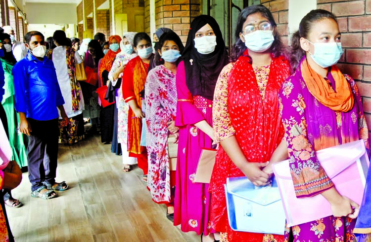 Aspirants stand in a queue to fill their college admission forms for the new academic session 2020-21 at Siddheshwari Girls' School and College in the capital on Sunday.