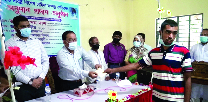 Swapan Kumar Das, Chairman of Fakirhat Upazila in Bagherhat, hands over donation among the distressed people at a function organized by Sheikh Lutfor Rahman Foundation on Wednesday.