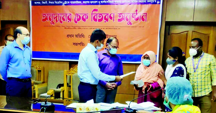 Deputy Commissioner of Dhaka Shahidul Islam distributes cheques of financial assistance among the patients afflicted with cancer, paralysis and kidney disease at the seminar room of his office on Wednesday.