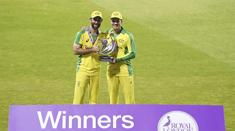 Australia's Glenn Maxwell (left) and Alex Carey pose with the winner's trophy after their win in the third ODI cricket match between England and Australia, at Old Trafford in Manchester on Wednesday.