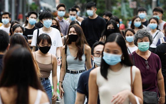 People cross a street at the shopping district of Orchard Road amid the coronavirus outbreak in Singapore.