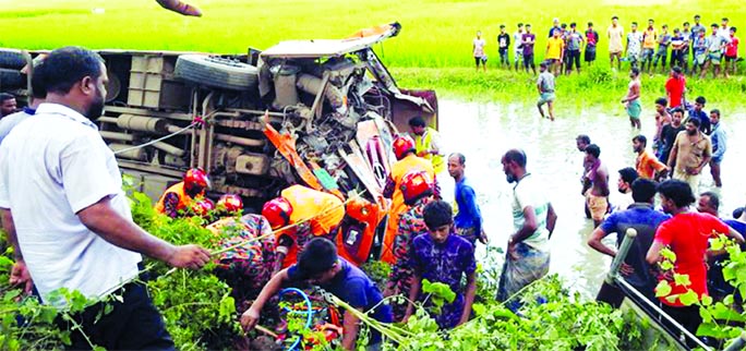 A bus plunges into a roadside ditch after colliding head-on with another vehicle at Mughurdhal in Magura's Sadar upazila on Friday.