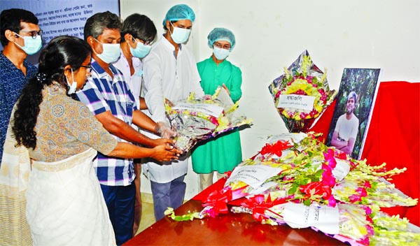 Leaders of Bangladesh Garments Sramik Sanghati pay tributes to its leader Aminul Islam Shama placing floral wreaths at his temporary portrait at the Jatiya Press Club on Friday.
