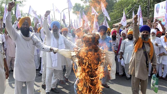 Farmers shout slogans as they burn effigies of Indian PM Narendra Modi and Agriculture Minister Narendra Singh Tomar, in Amritsar, Punjab.