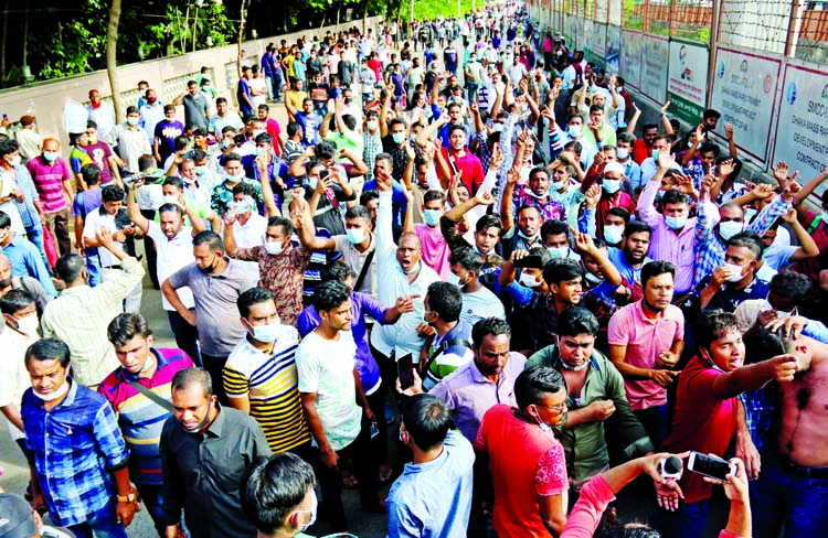 Bangladeshi expatriate workers, who get stranded at home during Covid-19 pandemic, block road in front of Saudi Airlines office at Sonargaon Hotel in the capital on Monday seeking air tickets to join their workplaces again.