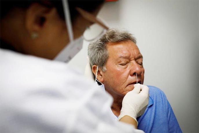 A volunteer reacts while a swab sample is taken as he participates in a coronavirus vaccination study at the Research Centers of America, in Hollywood, Florida, US, on Thursday.