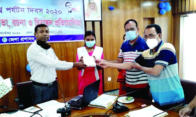 Md Yearul Islam, Additional Deputy Commissioner of Narail, handing over prizes among the winners of essay and painting competition held in the auditorium of DC office on Sunday, organized by the district administration on the occasion of World Tourism Day