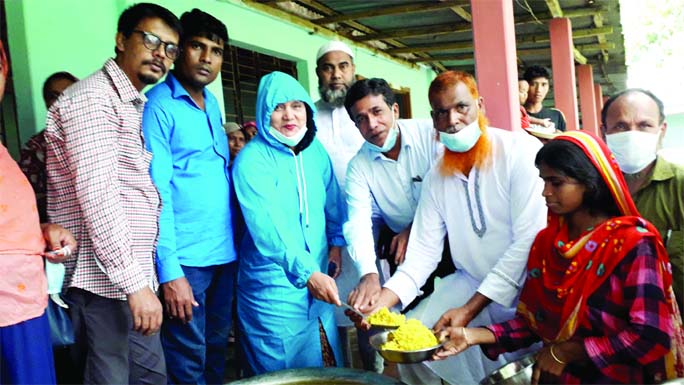 Faruk Alam Toby, Chairman of Boda Upazila Parishad of Panchagarh District, distributes cooking food among the flood-hit people of the upazila on Sunday.