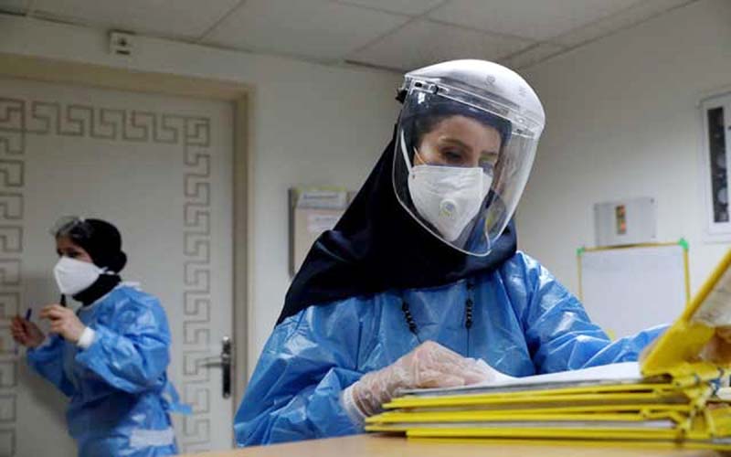 A nurse wearing a protective suit and mask checks the files at Hazrate Ali Asghar Hospital amid the coronavirus, in Tehran, Iran.