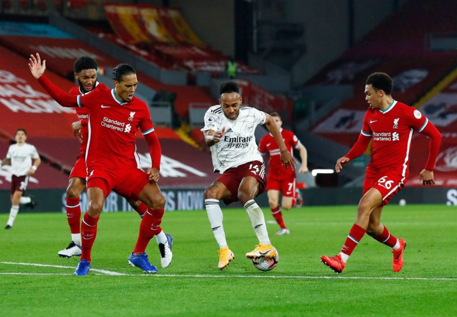 Arsenal's Pierre-Emerick Aubameyang (center) in action with Liverpool's Virgil van Dijk (left) during their Premier League match at Anfield, Liverpool on Monday.