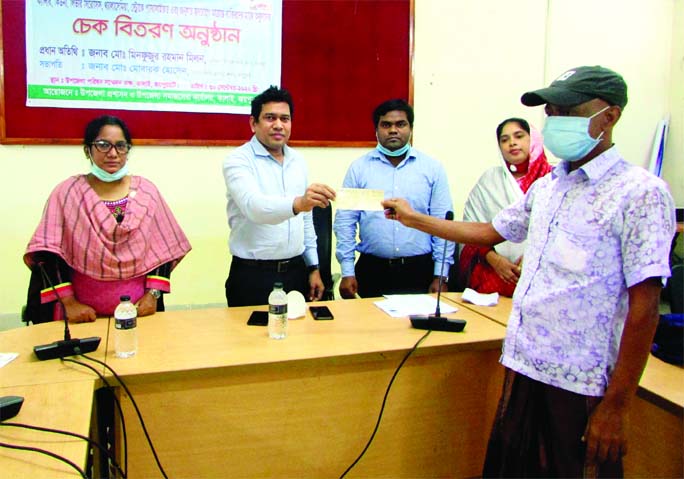 UNO of Kalai Upazila in Joypurhat district Mobarak Hossain distributes cheques among the patients with complex diseases at the Upazila Social Welfare Office on Wednesday.