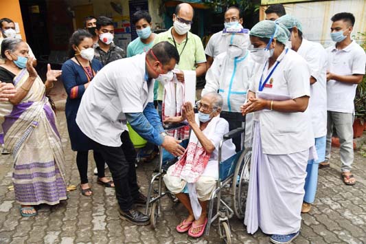 An elderly Indian woman leaves hospital in Guwahati after recovering from coronavirus.
