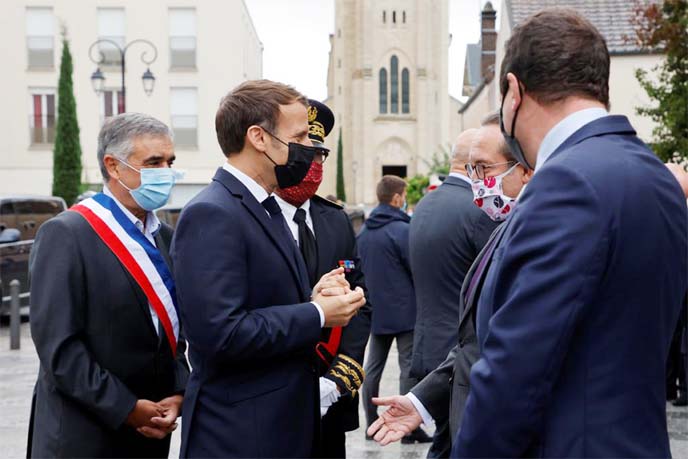 French President Emmanuel Macron speaks with President of Yvelines Departmental Council Pierre Bedier, prior a speech presenting his strategy to fight separatism, in Les Mureaux, near Paris, France on Friday.