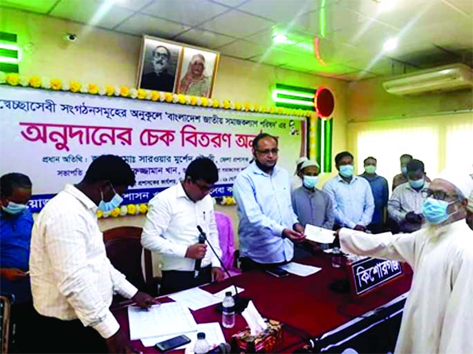 Deputy Commissioner (DC) of Kishoreganj Sarowar Morshed Chowdhury distributes cheques among the Social organizations organized by Social Service Department at local collectorate conference room on Wednesday.
