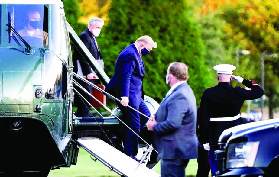 President Donald Trump arrives at Walter Reed National Military Medical Center, in Bethesda, Md on Friday on Marine One helicopter after he tested positive for COVID-19. White House chief of staff Mark Meadows is at second from left.