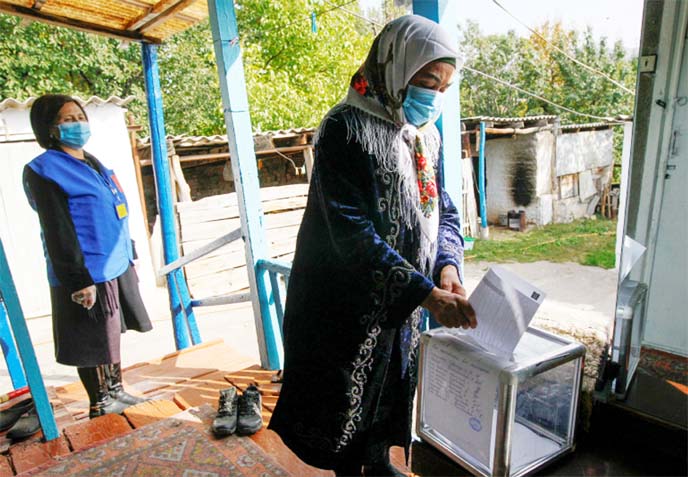 A woman casts a ballot at home during the parliamentary election in the village of Arashan, Kyrgyzstan.