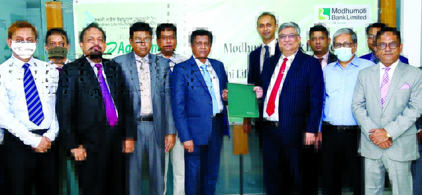 Md. Shafiul Azam, Managing Director of Modhumoti Bank Limited and Nemai Kumer Saha, Managing Director of Sandhani Life Insurance Company Limited, exchanging an agreement signing document at the bank's head office in the city on Monday. Under the deal, cu