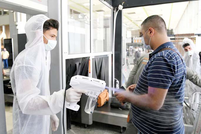 A health worker sprays sanitizer on a passenger at Damascus International Airport on its re-opening day for regular international commercial traffic after months of closure following the coronavirus outbreak.