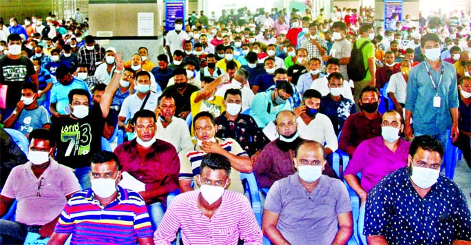 Saudi returnees wait for Covid-19 test at the DNCC Market in Mohakhali, Dhaka on Friday such test mandatory for overseas trip.