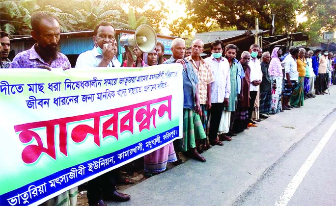 Fishermen form a human chain at Kamarkhali bus stand in Madhukhali of Faridpur district on Thursday demanding food aid during the upcoming hilsa fishing ban from Oct 14 to Nov 4.