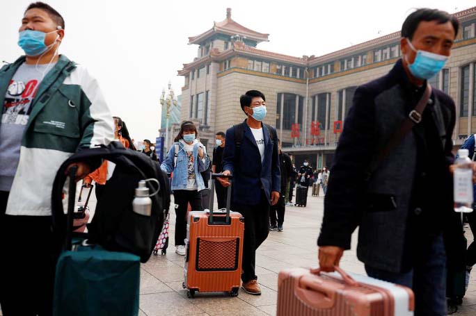 People arrive at Beijing Railway Station after an eight-day National Day holiday following the outbreak of the coronavirus in Beijing, China.