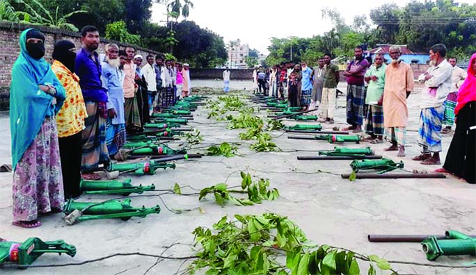 A non-government organization provided tube-wells and saplings to 50 poor families of Melandah Upazila in Jamalpur District on Monday. The recipients are seen in this photo.