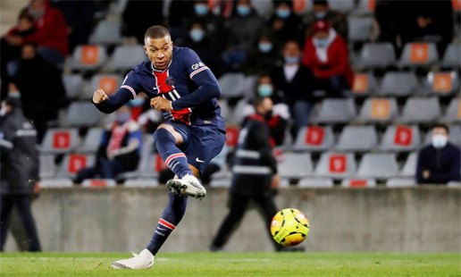 Paris St Germain superstar Kylian Mbappe scores their third goal in their Ligue 1 match against Nimes at the Stade des Costieres in Nimes on Friday.