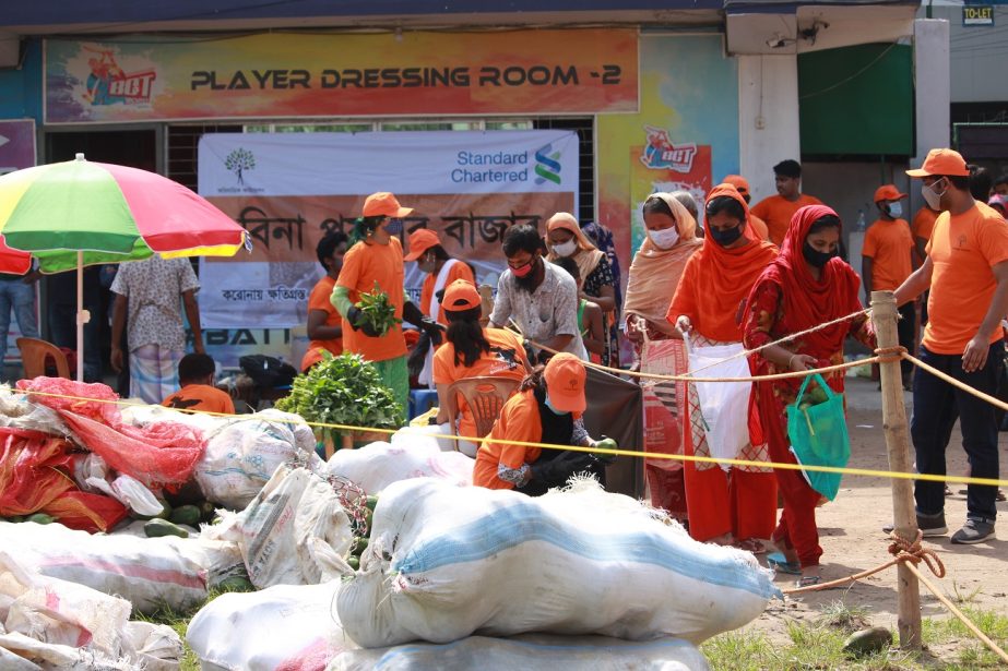 Employees of the Standard Chartered Bangladesh and OBHIZATRIK Foundation distributing fresh food and vegetables among the distressed communities in the city on Saturday.