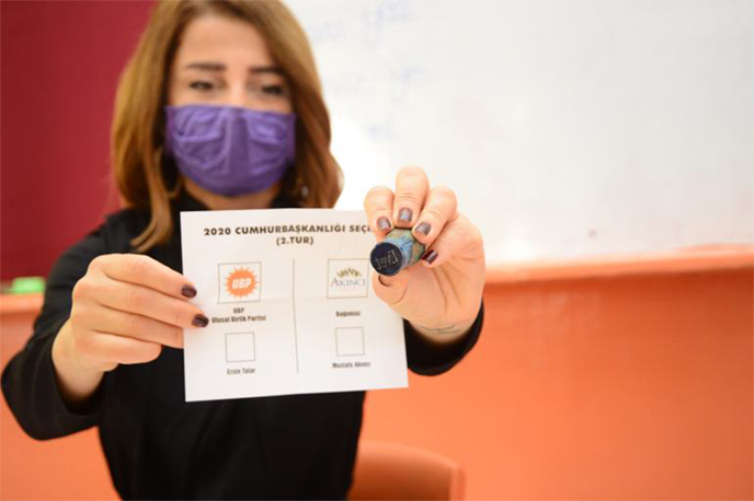 A polling clerk shows a ballot paper and a voting stamp at a polling station during the second round of presidential elections in Nicosia, Turkish Republic of Northern Cyprus.