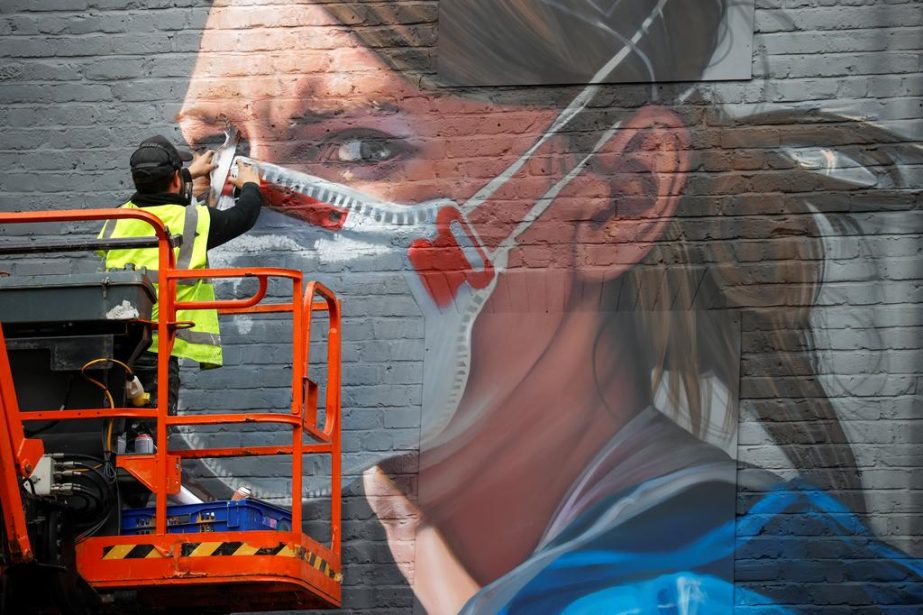 An artist works on a mural as the coronavirus outbreak continues, in Manchester, Britain on Sunday.