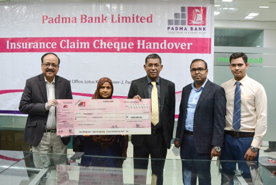 Md Ehsan Khasru, Managing Director and CEO of Padma Bank Limited, handing over a group insurance cheque of Tk 3 lakh to its nominee Md. Dulal Talukder who died during his service at the banks head office in the city on Sunday. M Ahsan Ullah Khan, Head of