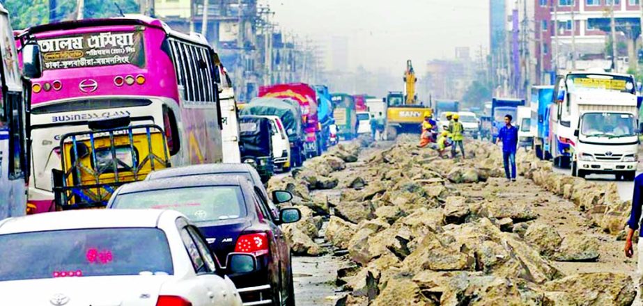 Vehicles struggle to cross through the busy Kunia road in Gazipur as it has become narrow due to the placement of large concrete blocks on its middle for the construction work of the Bus Rapid Transit (BRT) project.