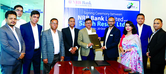 Mamoon Mahmood Shah, Managing Director of NRB Bank Limited and Ahmad Raquib, General Manager of Sara Resort (a sister concern of Fortis Group Limited), exchanging documents after signing an agreement at the bank's head office in the city on Tuesday. Unde