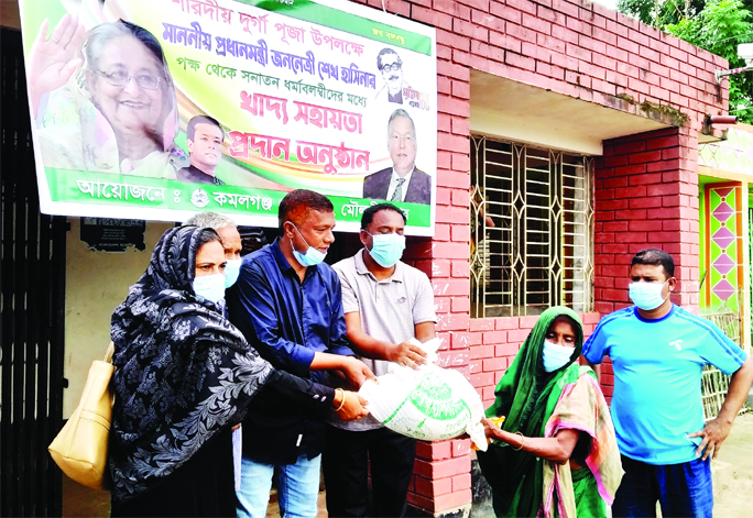 Kamalganj (Sylhet) Pouro Mayor Md Jewel Ahmed distributes foods among the members of the minority community on the occasion of Durga Puja on Tuesday.