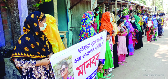 A cross section of people form a human chain at Dakalibandha Bazar in Hatibandha of Lalmonithat district on Wednesday protesting alleged rape of a housewife by one Alamgir Hossain.