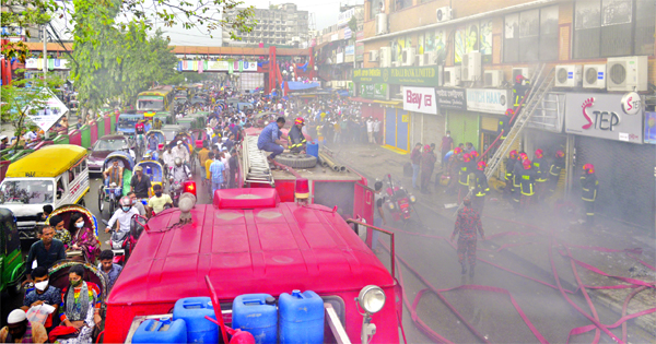 Fire fighters are seen working to douse the fire at Balaka Bhaban in Chandni Chowk Market in the capital on Wednesday.