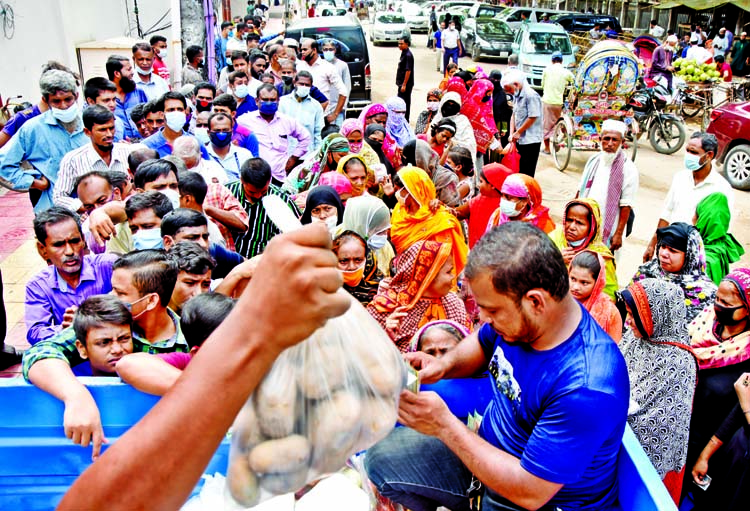 People queue up in front of a Trading Corporation of Bangladesh (TCB) truck near the National Press Club in the capital to buy potatoes at subsidized price on Wednesday. TCB started the open market sale (OMS) of potatoes at Tk 25 per kilogram from yesterd