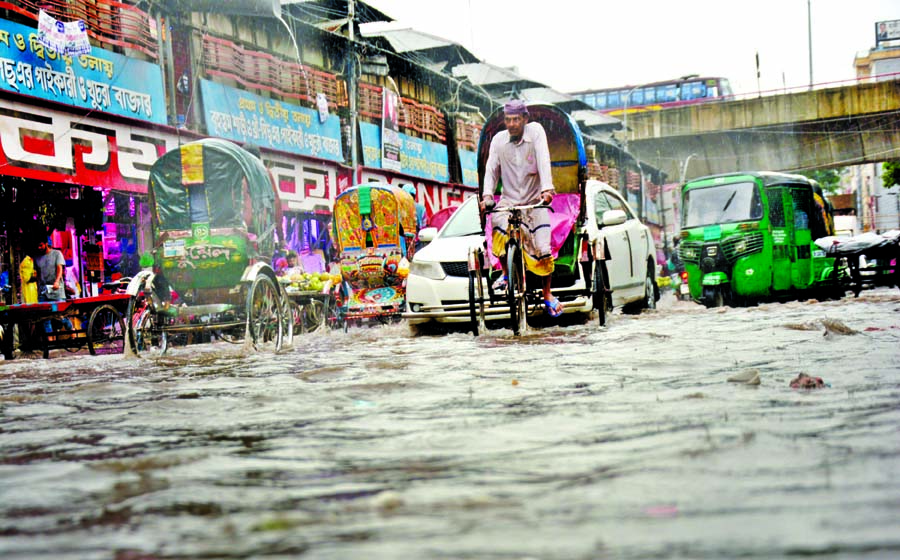 A road near Bangobazar in the capital goes under water following incessant rain on Thursday.