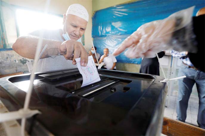 A man casts his ballot at a school used as a polling station, during the first round of Egypt's parliamentary elections in Giza, Egypt on Saturday.