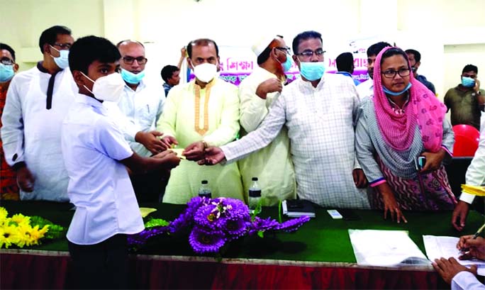 Prof. Dr. Md. Abdul Aziz, MP, hands over financial grants to the meritorious students of Government Primary Schools at a ceremony in the Tarash Upazila Parishad auditorium in Sirajganj on Sunday morning. Upazila Nirbahi Officer Mejbaul Karim presided over