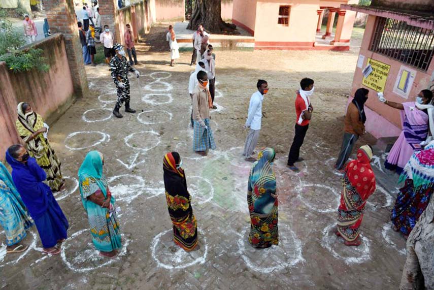 Voters queue up, maintaining distancing, at a polling station at Paliganj, Bihar.