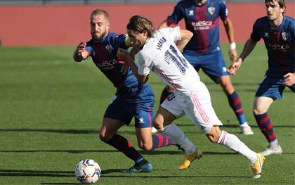 Real Madrid's Luka Modric (right front) vies with Huesca's Jorge Pulido (left) during a Spanish La Liga soccer match between Real Madrid and SD Huesca in Madrid, Spain on Saturday.